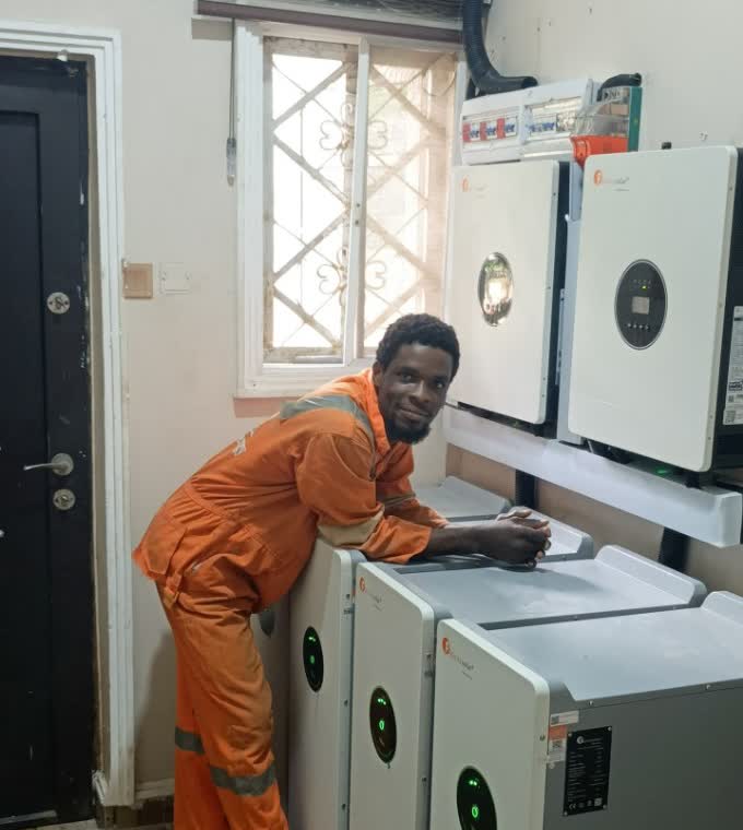 Technician working on installed inverters and lithium batteries